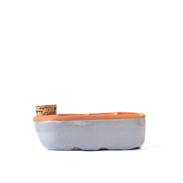 Ceramic planter with terracotta top and cork base on a white background