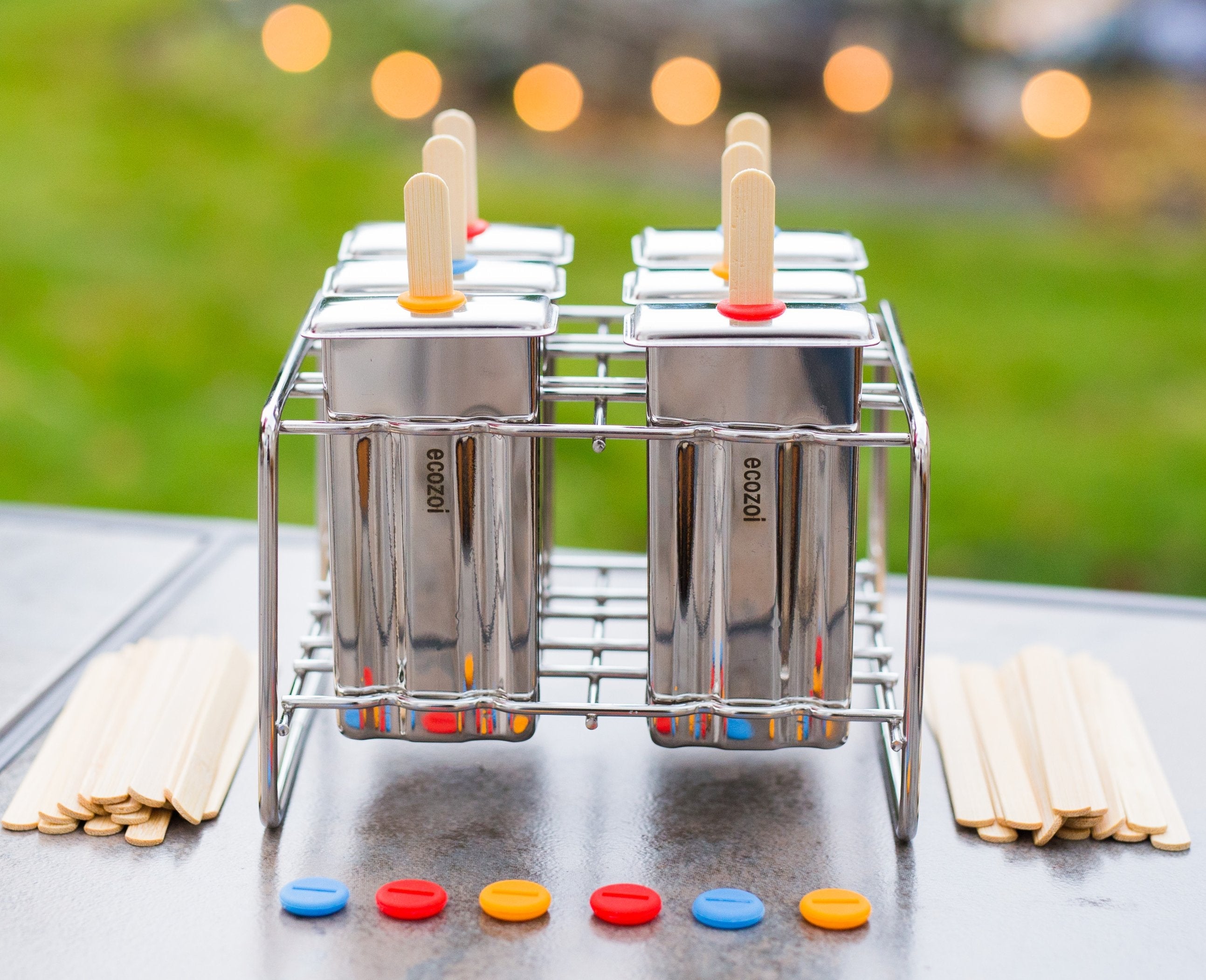 Popsicle mold with colorful sticks on a metal rack outdoors