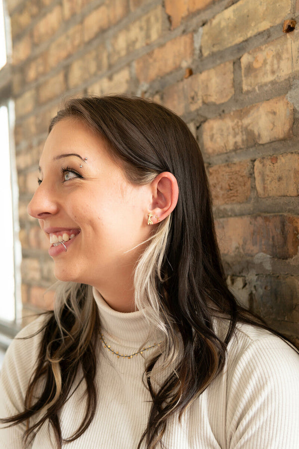Stand Tall Studs handmade fair trade brass stud earrings styled on model