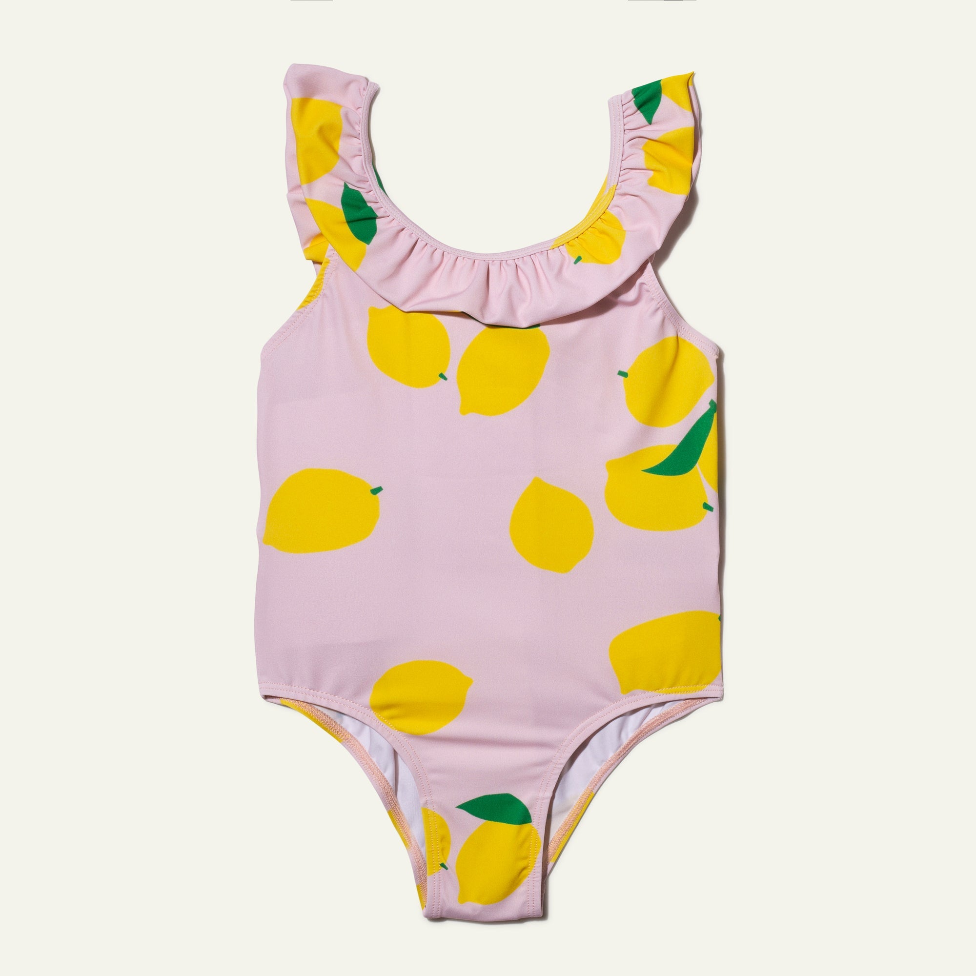 Pink one-piece swimsuit with lemon pattern on a light gray background
