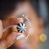 Hand holding a black and white striped candy with 'A Sweet Escape' text.