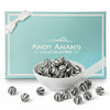 Bowl of striped chocolates in front of a turquoise box with 'Andy Anand Chocolatier' branding.