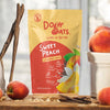 Doby Oats Sweet Peach overnight oats package on a wooden surface with peaches and cinnamon sticks.