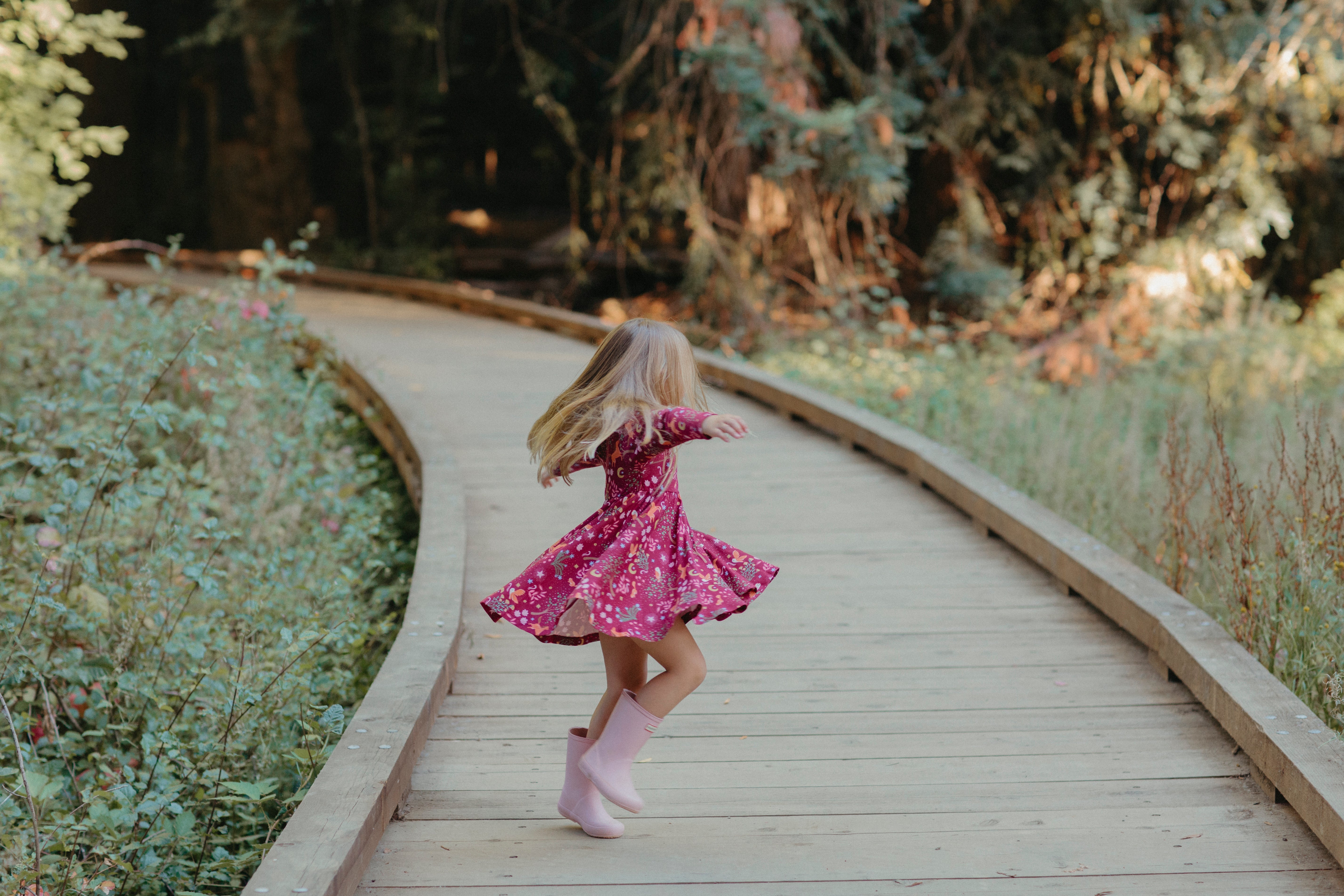 Young girl wearing the Apple Park Woodland Dreams long sleeve twirly dress, showing full skirt in motion