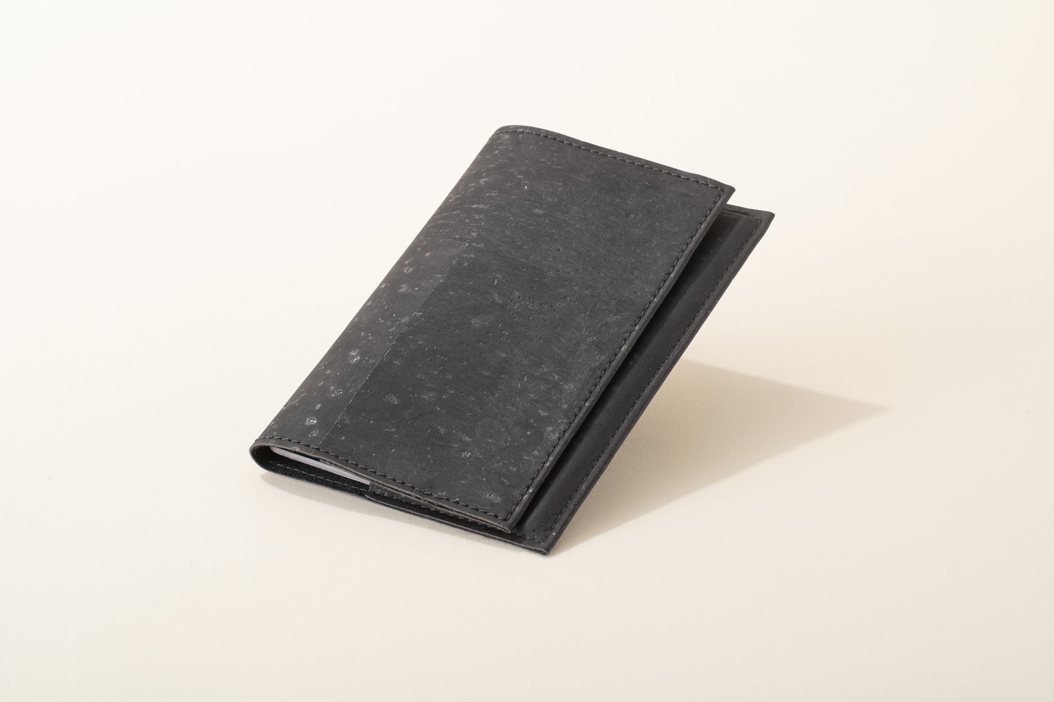 Black leather wallet on a beige background