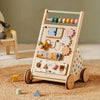 Wooden activity toy with wheels on a textured surface