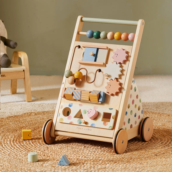 Wooden activity toy with wheels on a textured surface