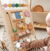 Child playing with a wooden activity toy in a home setting
