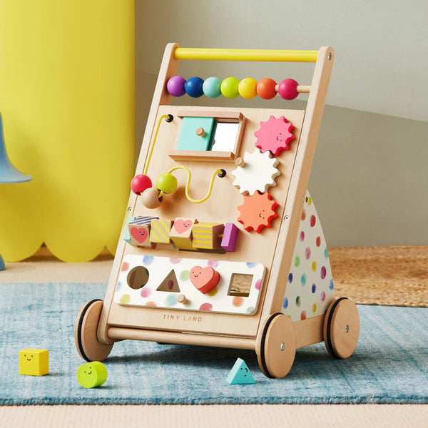Wooden activity walker with colorful beads and shapes on a blue mat