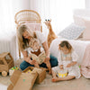 Woman reading a book to two children in a cozy living room.