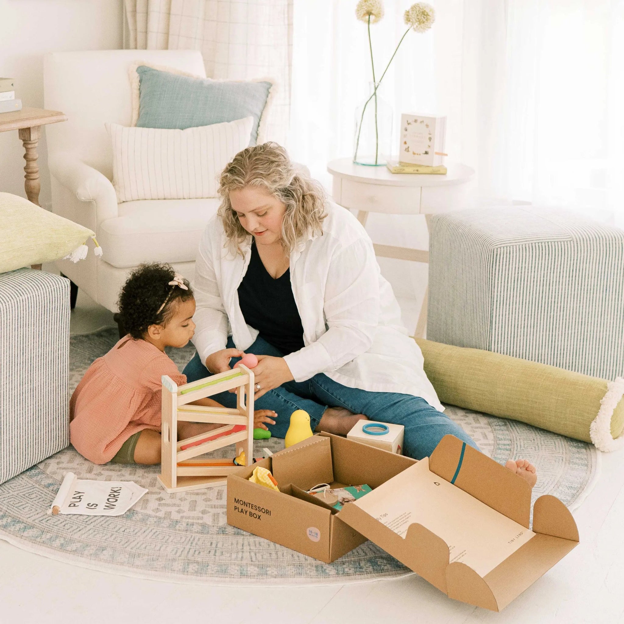 Woman and child playing with toys on a rug in a living room