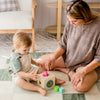 Woman and child playing with colorful blocks on a rug