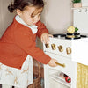 Child playing with a toy kitchen set