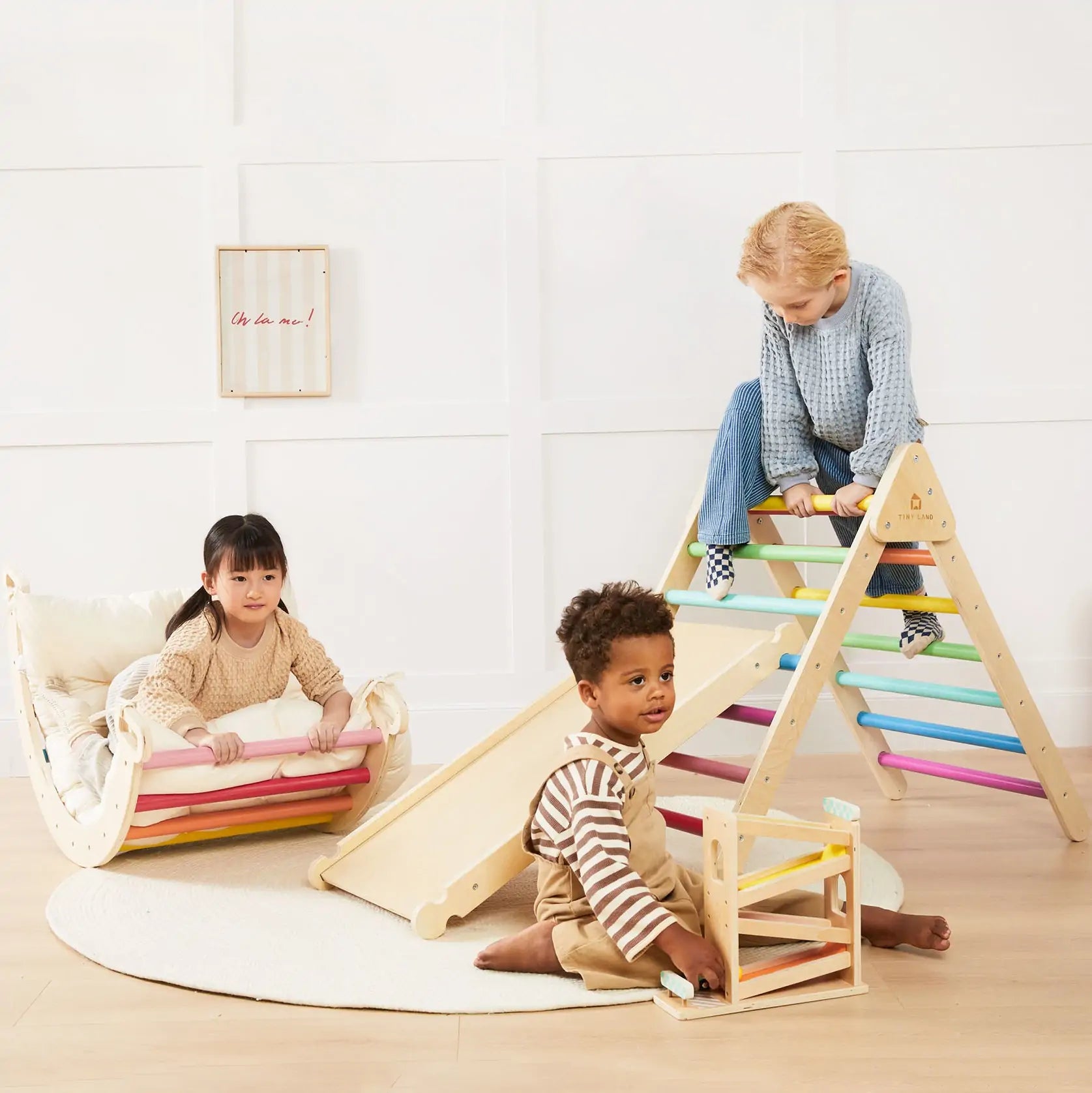 Child climbing the Tiny Land Montessori Pikler Triangle with detachable slide and cushioned mat
