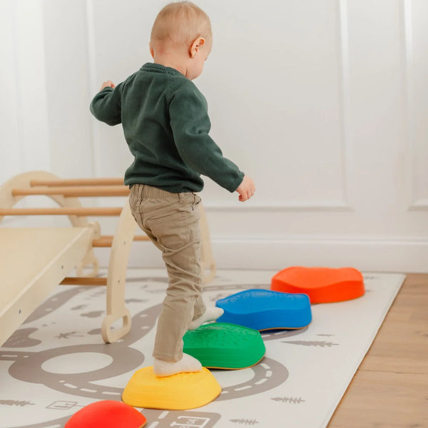 Child playing on colorful stepping stones in a home setting
