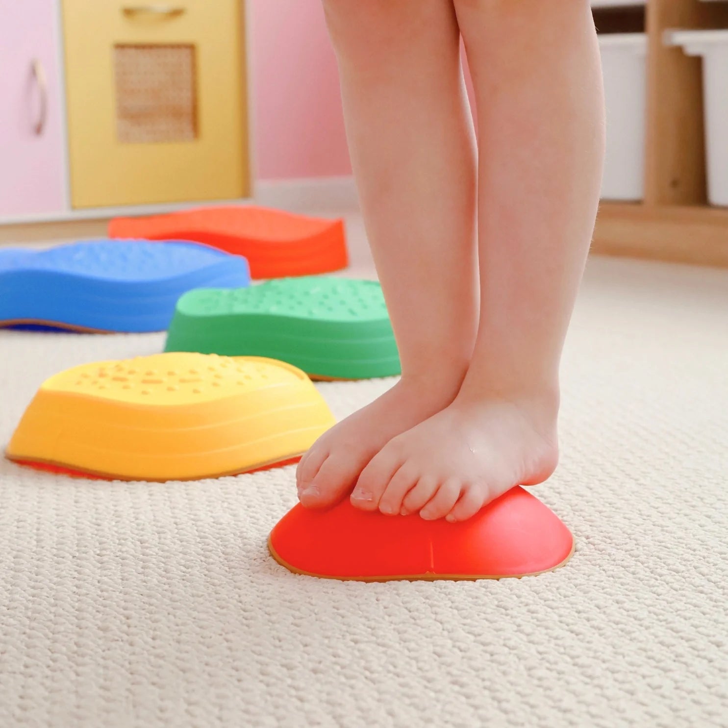 Child's feet stepping on colorful foam steps in a home setting