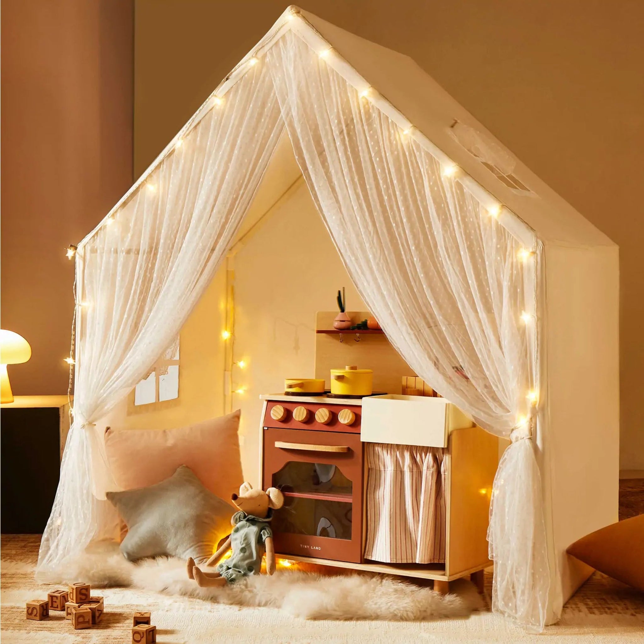 Children's playhouse with curtains and fairy lights in a cozy room.