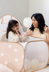 Woman and child playing with a star-patterned playpen.