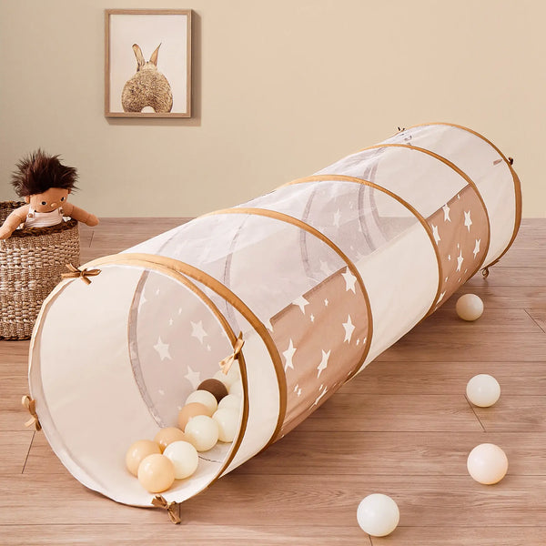 Children's play tunnel with balls on a wooden floor in a room.