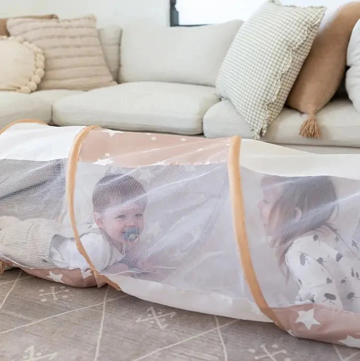Children playing inside a transparent playpen with beige border in a living room.