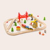 Wooden toy train set with tracks, bridges, and small buildings on a beige background