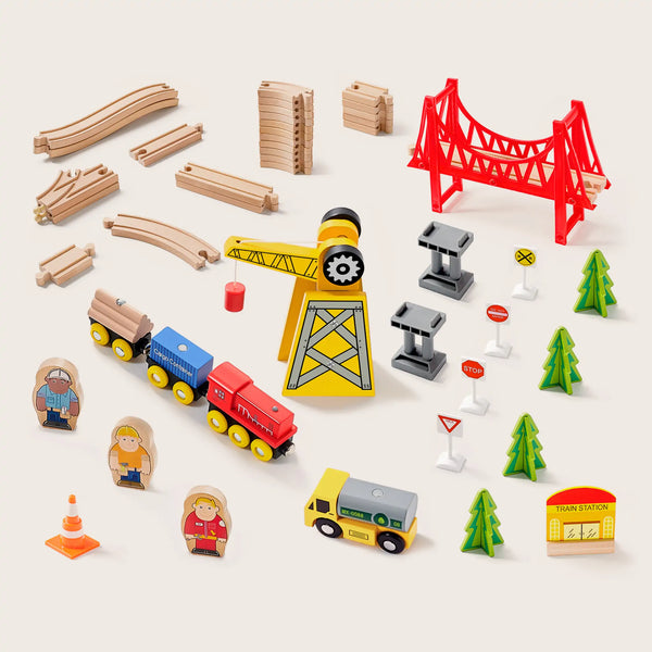 Collection of toy construction elements including a crane, train, and various structures on a white background