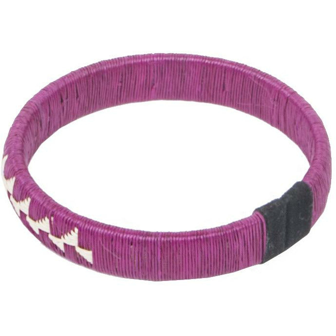 Overhead view of a fuchsia woven palm flower bracelet made from palm thread and copper craft wire