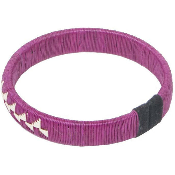 Overhead view of a fuchsia woven palm flower bracelet made from palm thread and copper craft wire