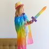 Child in a rainbow-themed costume with a sword, standing against a plain background.