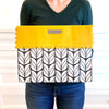 Flat-lay of EverWrap EverEnvelope foldable reusable gift wrap bag in black, white and marigold
