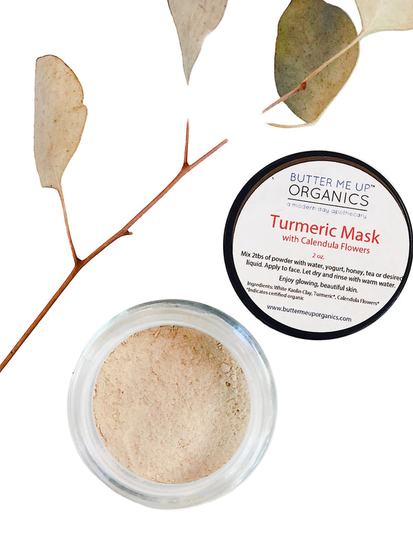 Turmeric Face Mask by Butter Me Up Organics displayed with natural ingredients including calendula flowers and turmeric