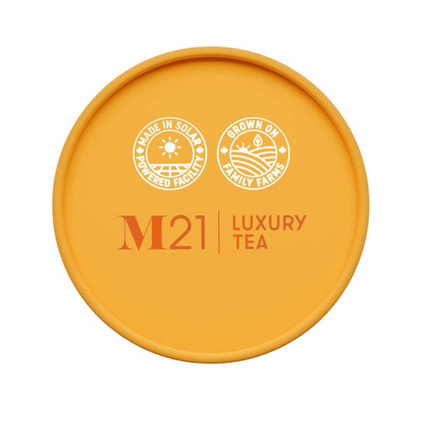 Yellow lid of M21 Luxury Tea packaging with branding and sustainability icons.