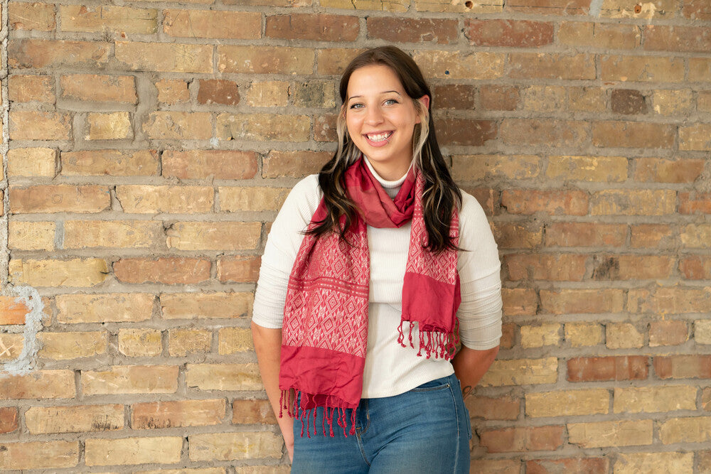 Model wearing the Tuyen raspberry scarf loosely wrapped, showing full length and pattern detail