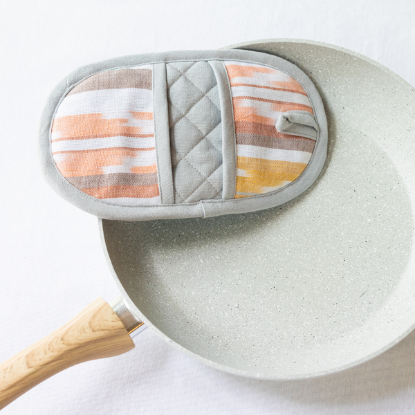 Protect your hands in style with our Double-Ended Oval Pot Holder. This versatile kitchen accessory is made from sustainable cotton and offers double the protection against heat.