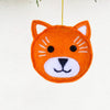 Orange fox ornament hanging from a Christmas tree.
