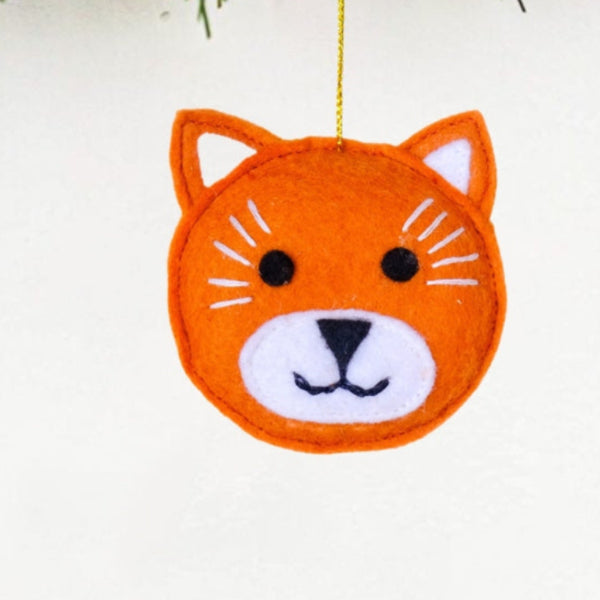 Orange fox ornament hanging from a Christmas tree.