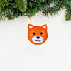 Orange fox ornament hanging from a Christmas tree