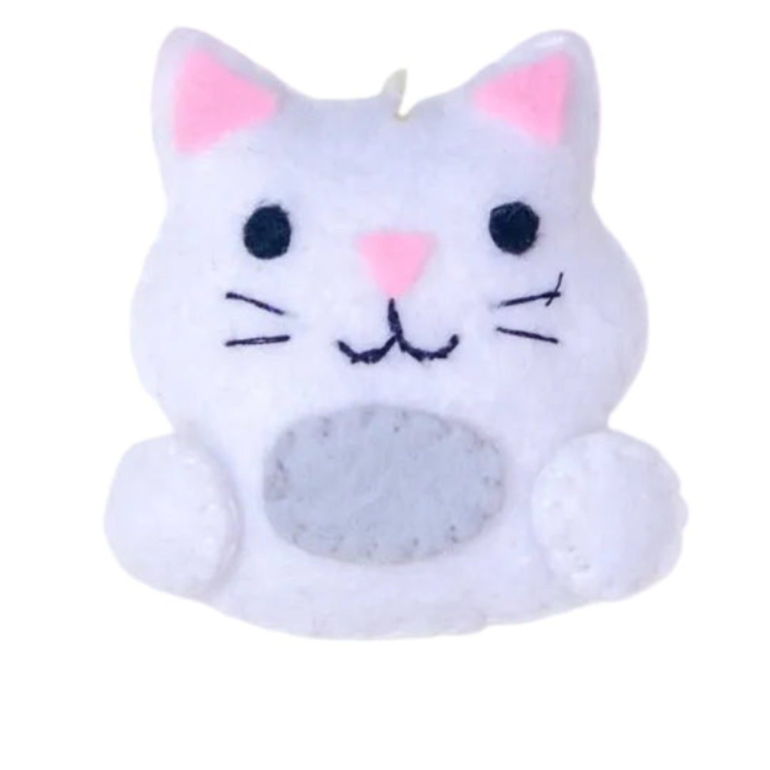 Cat-shaped ornament on a white background with greenery above