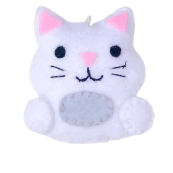 Cat-shaped ornament on a white background with greenery above
