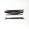 Vanilla beans arranged on a white background