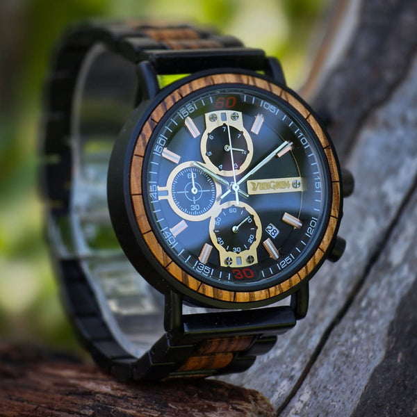 Black and gold wooden chronograph watch on wrist showing adjustable black link strap