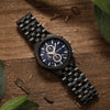 Handcrafted ebony wood chronograph watch with sub-dials worn on man's wrist