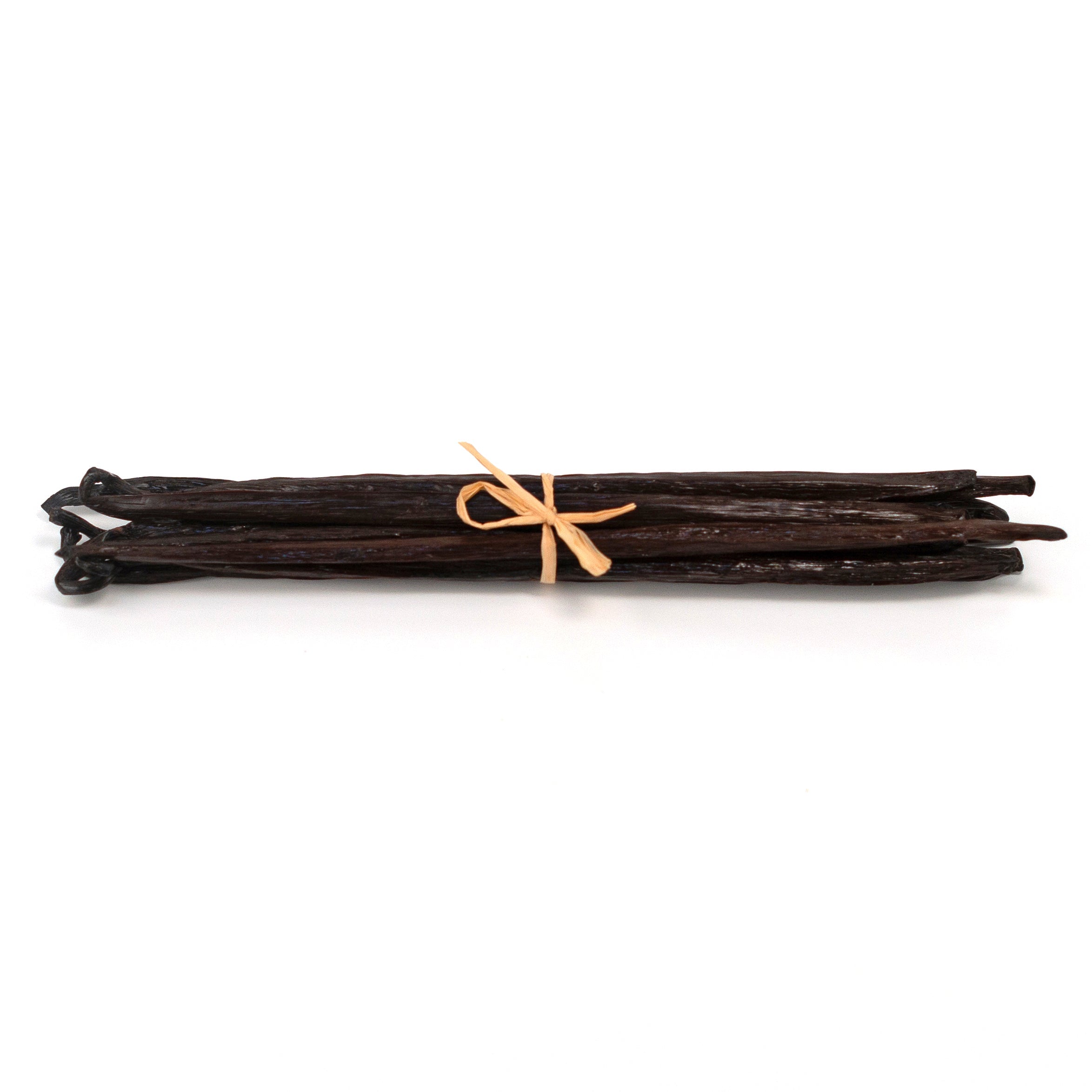 Vanilla beans tied with a ribbon on a white background