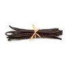 Vanilla beans tied with a ribbon on a white background