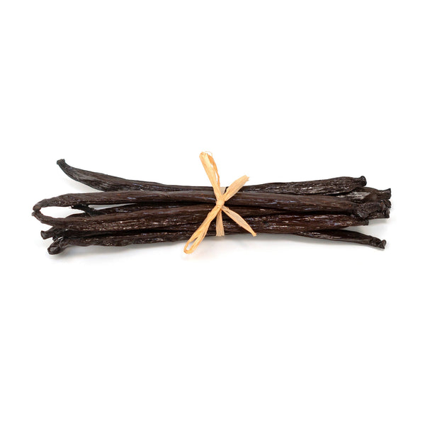Vanilla beans tied with a ribbon on a white background