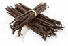 Bunch of vanilla beans tied with a rubber band on a white background