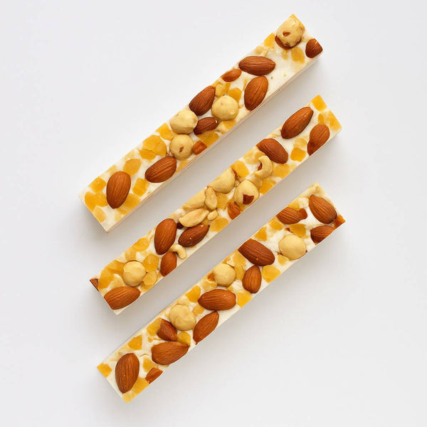 Two rectangular bars of nougat with nuts on a white background