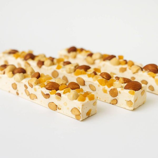 Two nougat bars with nuts on a white background