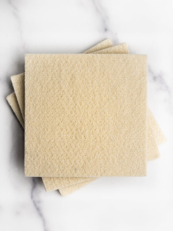 Three beige napkins on a marble surface