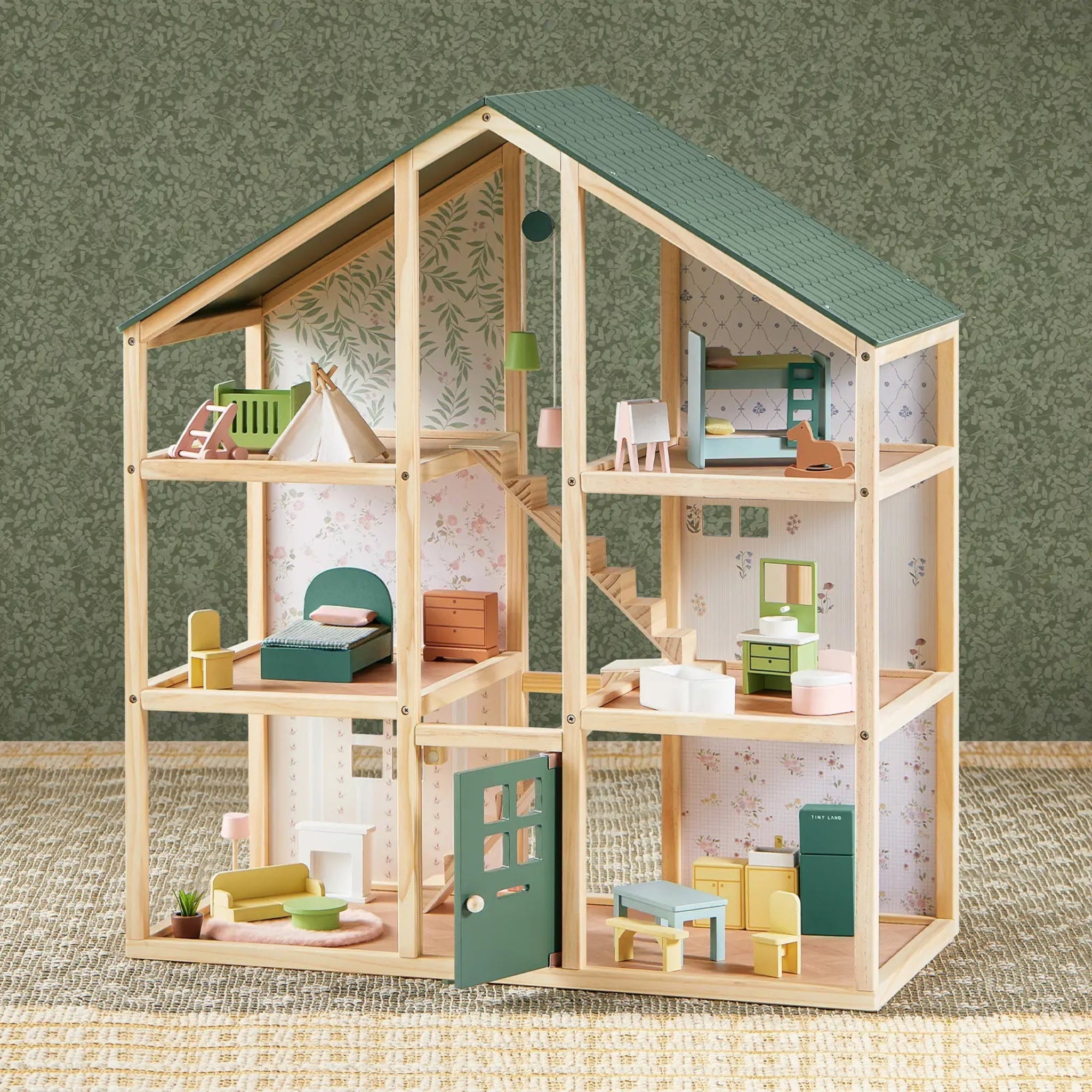 Wooden dollhouse with detailed interior and furniture on a textured surface.